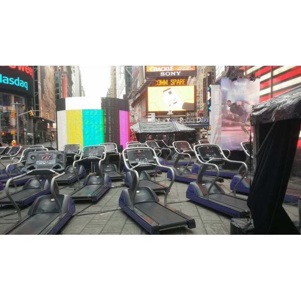 A row of treadmills on a street in Times Square, featuring both new and remanufactured gym equipment.