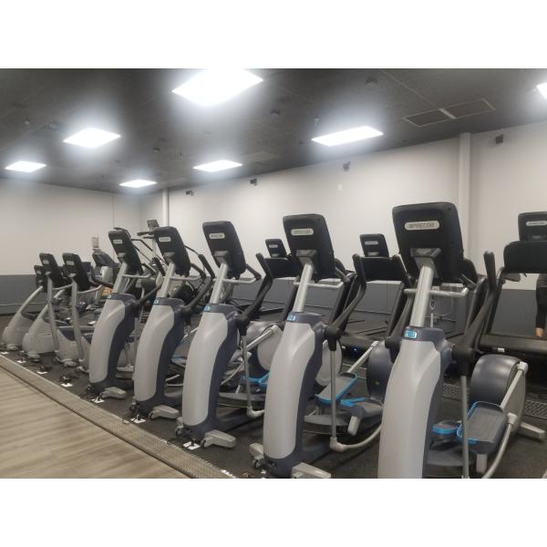 A row of exercise bikes in a gym, featuring new and remanufactured gym equipment.