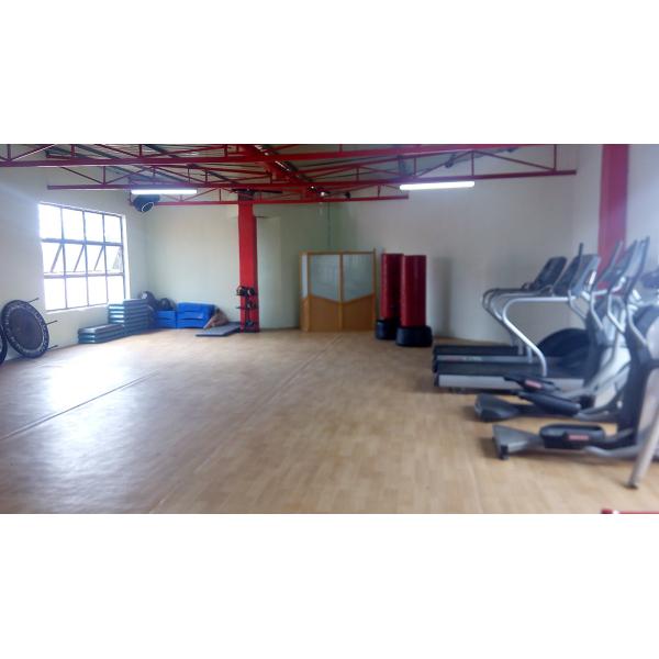 A gym room furnished with both new and remanufactured gym equipment, including tread machines and other exercise equipment.