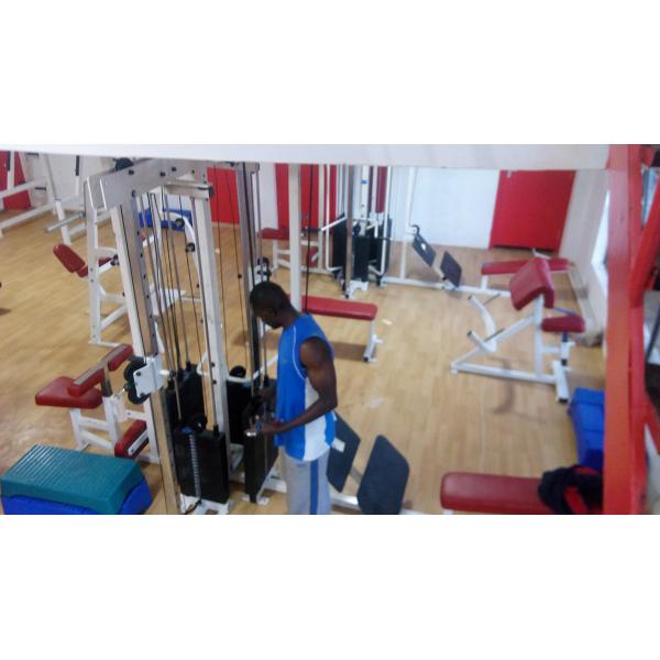 A man is working out in a gym using new gym equipment.