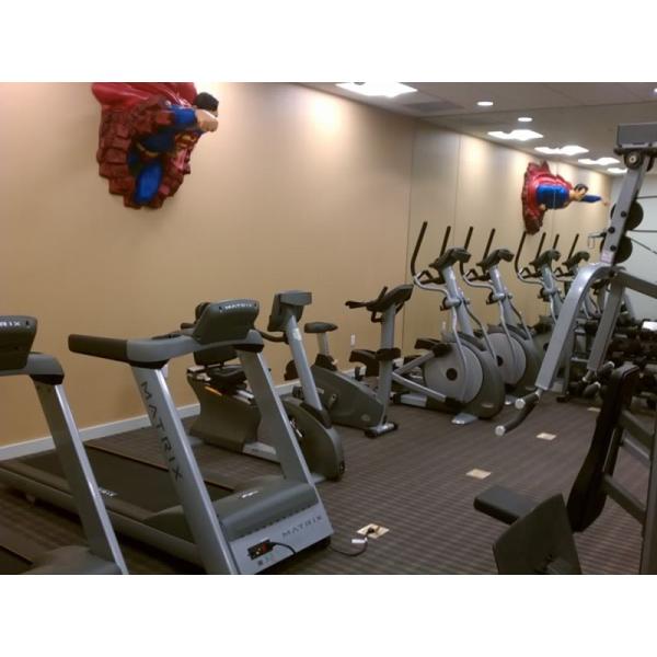 A new gym room with a superman statue on the wall.