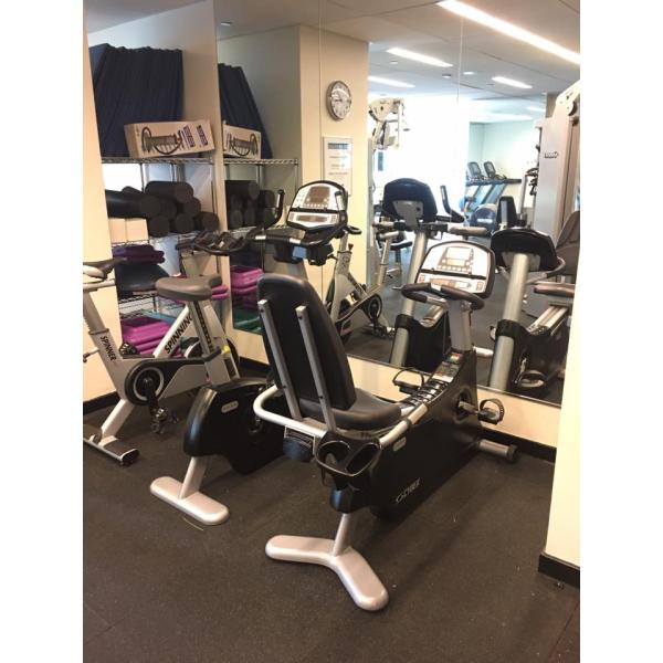 A gym room with several exercise bikes and mirrors featuring new gym equipment.