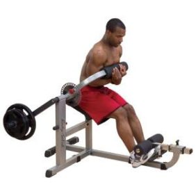 A man, surrounded by the Body Solid Cam Series Plate Loaded Ab & Back Machine - New, sits on a bench with a barbell.