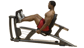 A man is sitting on a Body Solid Fusion Leg Press Attachment - New in a gym filled with a variety of new and remanufactured gym equipment.