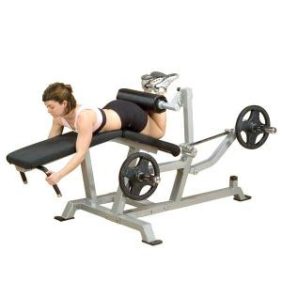 A woman using the Body Solid Leverage Plate Loaded Leg Curl - New machine for sit ups at the gym.