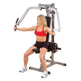 A woman is posing on a Body Solid Plate Loaded Pec Dec Machine - New.