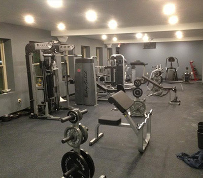 A gym with a lot of new and remanufactured gym equipment in it.