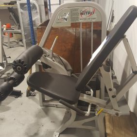 A new Nautilus Nitro Seated Leg Curl (Cleaned & Serviced) is sitting in a warehouse.