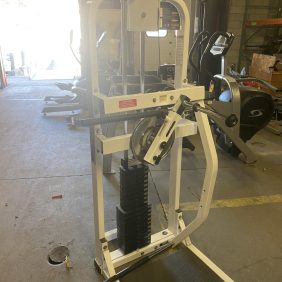 A warehouse filled with new and remanufactured gym equipment, including a Paramount Multi Hip - Remanufactured machine.