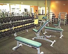 A gym with a lot of Rolled Rubber Flooring (Solid Black) and benches.