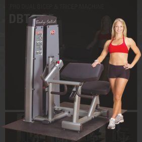 A woman is posing next to a new Body Solid DBTC-SF Pro Dual Bicep/Tricep Machine.