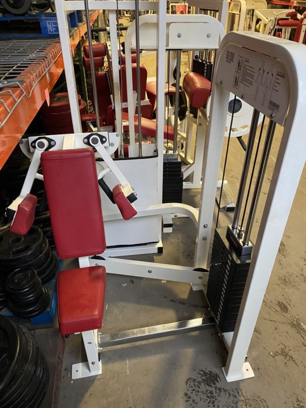 A new red and white gym machine in a warehouse.