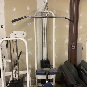 A gym machine with a bench and other equipment for New & Remanufactured Gym Equipment.