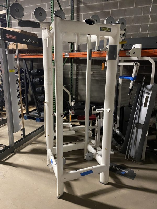 A gym with a squat rack and other equipment including the Technogym 4 Stack - As Is Functional.