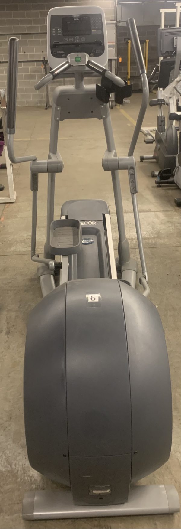 A Cybex 626 Arc Trainer - As Is Functional stands prominently in a gym, surrounded by other exercise equipment in the background.