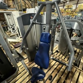 A Life Fitness Signature Series Chest Press, priced at $1350, sits prominently on wooden pallets in a warehouse.