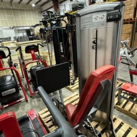 Inside the warehouse, with its high ceilings and storage boxes, rows of serviced gym equipment such as the Cybex VR3 Package are neatly organized on pallets. Priced at $20,895, this setup is ideal for fitness enthusiasts looking for quality gear.