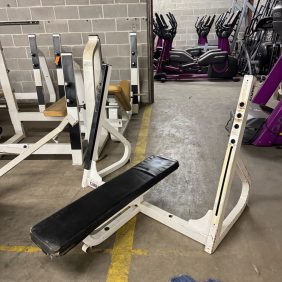 A Body Core Incline Bench - As Is Functional is nestled in an industrial-style room, surrounded by exercise bikes primed to challenge your core.