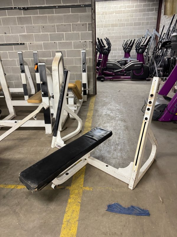 A Body Core Incline Bench - As Is Functional is nestled in an industrial-style room, surrounded by exercise bikes primed to challenge your core.