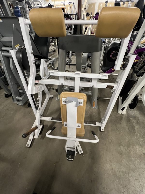 Reimagined with a sleek Precor design, the remanufactured gym leg press machine boasts tan cushions and a robust metal frame, resting elegantly on polished concrete.