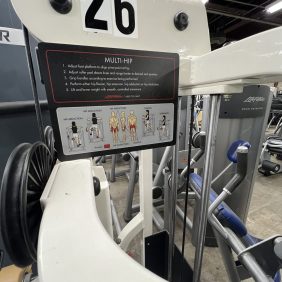 A remanufactured Precor Stretch Machine, featuring diagrams and text for easy use. It includes adjustable parts and is conveniently located on the gym floor, labeled "26," reflecting its versatile design and functionality.