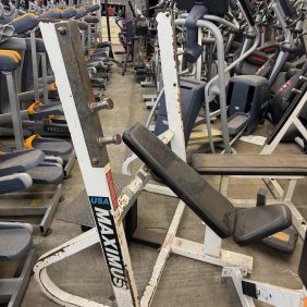 The Maximus Incline Bench Press - As Is Functional, despite its rusted frame, continues to operate among other gym equipment in storage.