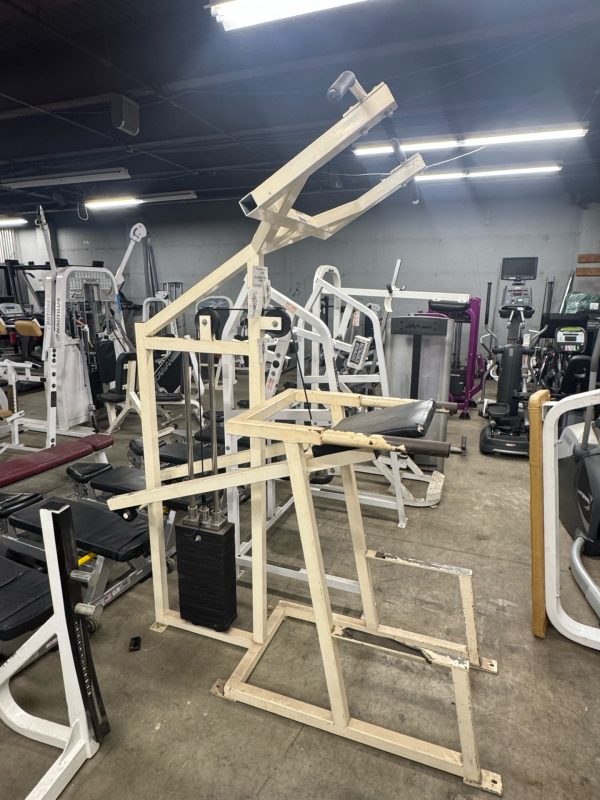 The True XFW 8200 Olympic 3 Way - New gym machine features a sturdy metal frame and padded seat, blending seamlessly with the various workout equipment in this Olympic-inspired gym.